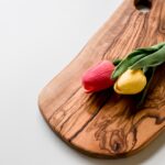 red and yellow tulips on brown wooden chopping board
