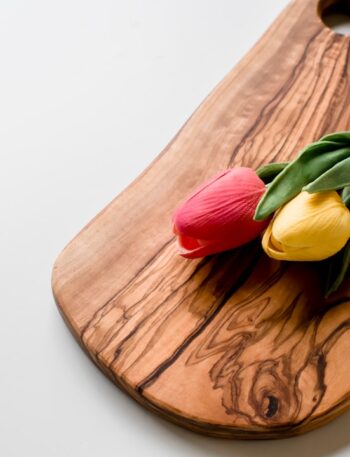 red and yellow tulips on brown wooden chopping board