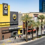 Buffalo Wild Wings located on the bustling Las Vegas Strip with palm trees and pedestrians.
