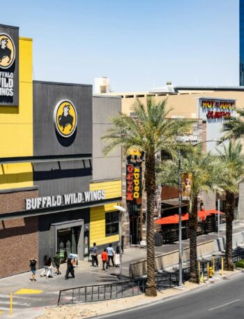 Buffalo Wild Wings located on the bustling Las Vegas Strip with palm trees and pedestrians.