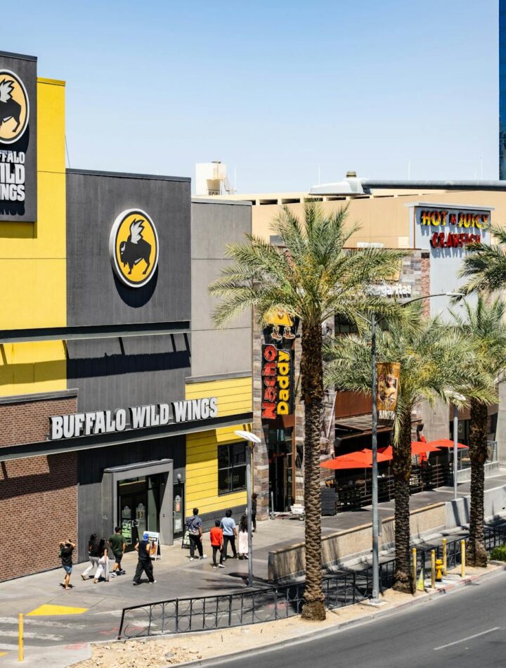 Buffalo Wild Wings located on the bustling Las Vegas Strip with palm trees and pedestrians.