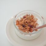 A bowl of cereal and a spoon on a plate