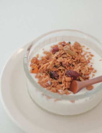 A bowl of cereal and a spoon on a plate