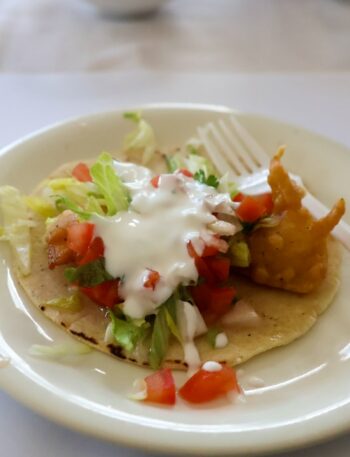 a white plate topped with a taco and a fork