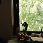 Table with fruit and window view of trees