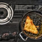 a frying pan filled with food on top of a stove