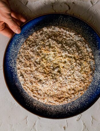 a person holding a plate of food on a table