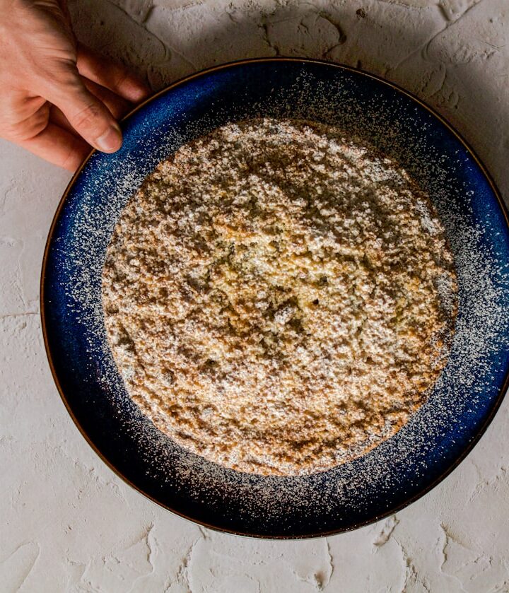 a person holding a plate of food on a table