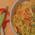 Bowl of noodles with vegetables and red pepper slices