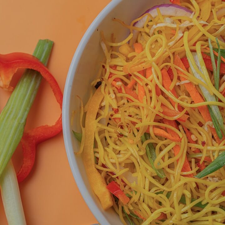 Bowl of noodles with vegetables and red pepper slices