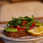 a white plate topped with a sandwich and a slice of lemon