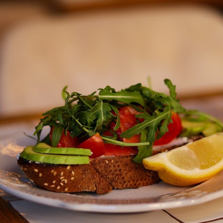 a white plate topped with a sandwich and a slice of lemon