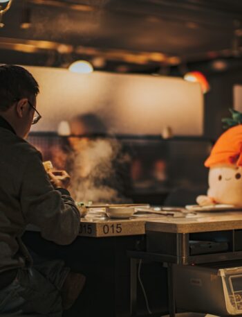 a man sitting at a table with a fake head on top of it