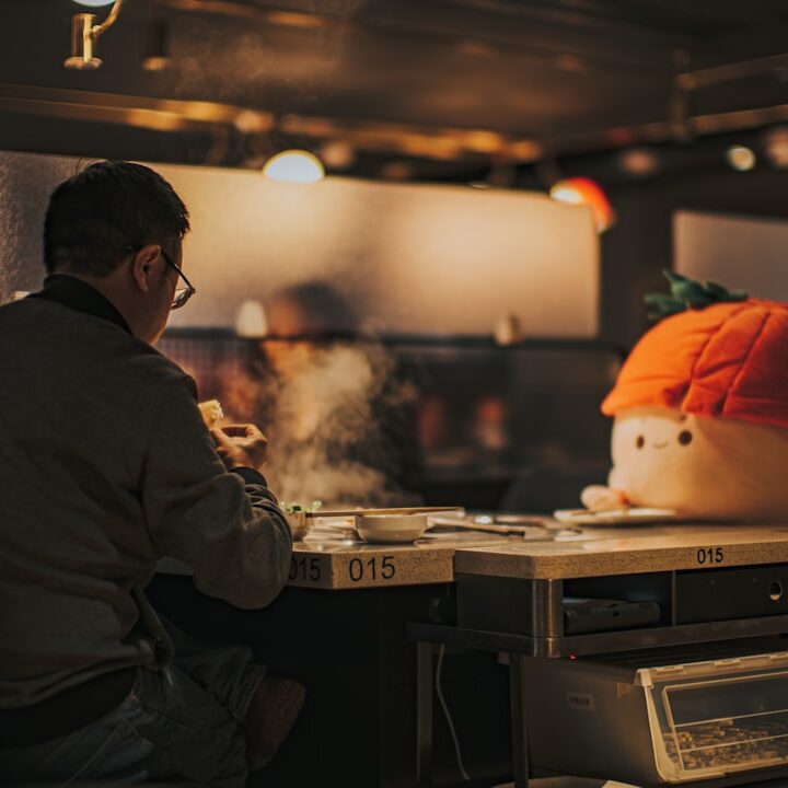 a man sitting at a table with a fake head on top of it