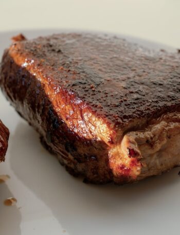 two pieces of steak on a white plate