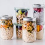 six full clear glass jars on white surface