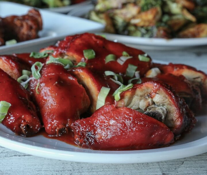a white plate topped with meat covered in sauce