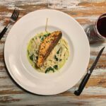 a white plate topped with pasta and chicken