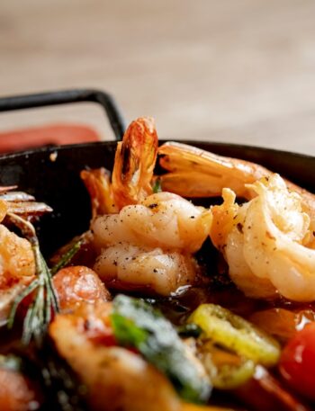 Cooked shrimp with tomatoes and herbs in a pan