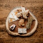 a wooden plate topped with cheese and crackers