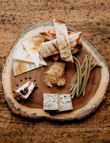 a wooden plate topped with cheese and crackers