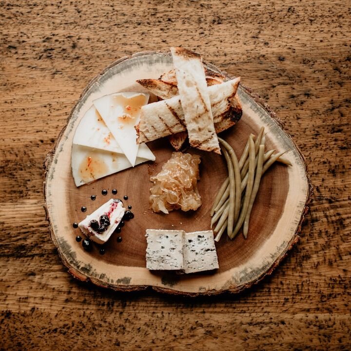a wooden plate topped with cheese and crackers