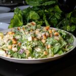 Delicious caesar salad is presented on a table.