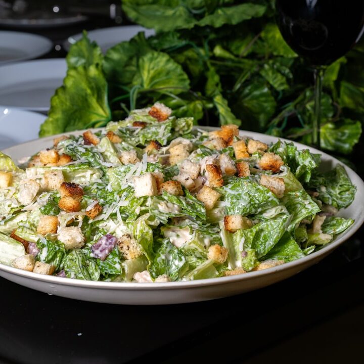 Delicious caesar salad is presented on a table.