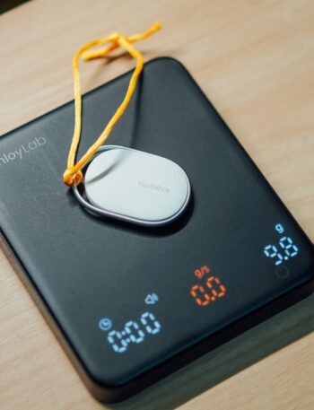 A digital scale with a small white device on top.
