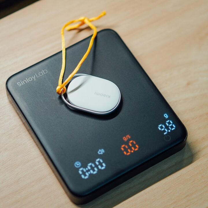 A digital scale with a small white device on top.