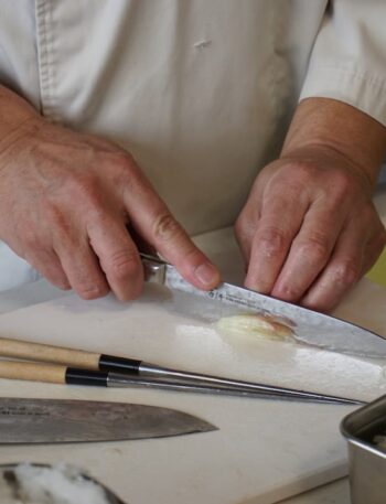person in white button up shirt holding silver knife