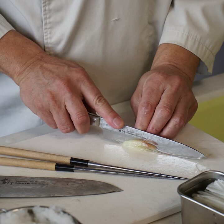 person in white button up shirt holding silver knife
